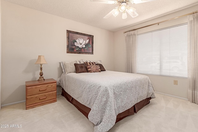 carpeted bedroom featuring ceiling fan and a textured ceiling