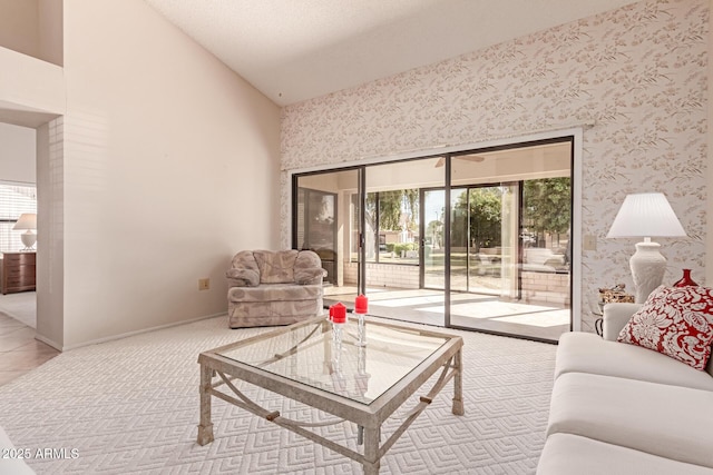 carpeted living room featuring high vaulted ceiling