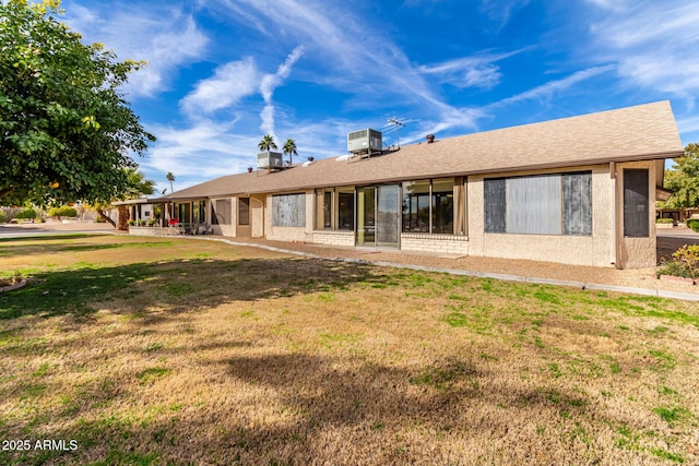 back of property with cooling unit and a yard