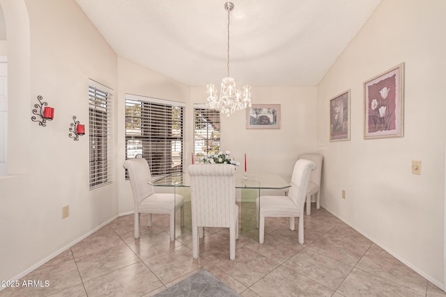 tiled dining space featuring lofted ceiling and a chandelier