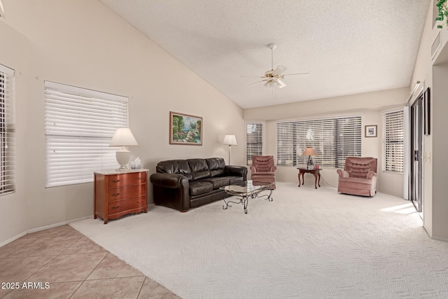 living room with light carpet, a textured ceiling, high vaulted ceiling, and ceiling fan