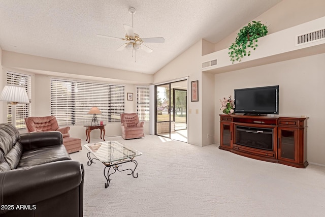 carpeted living room featuring lofted ceiling, a textured ceiling, and ceiling fan