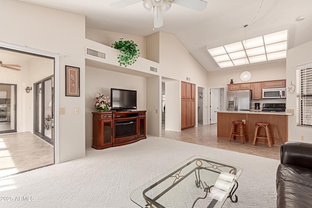 living room featuring ceiling fan, high vaulted ceiling, and light carpet