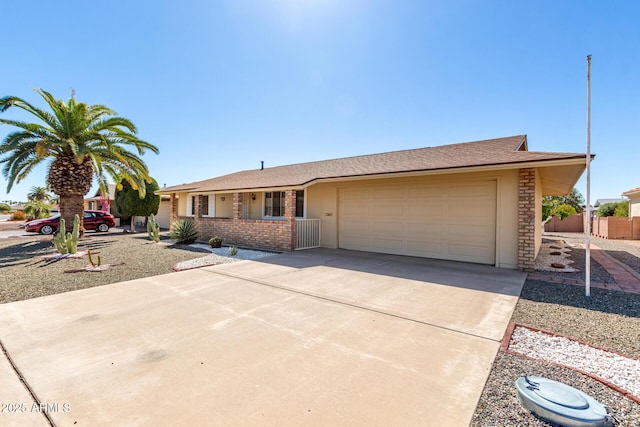 single story home with driveway, brick siding, an attached garage, and fence