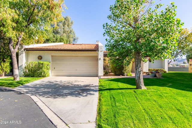 view of front of house with a garage and a front lawn