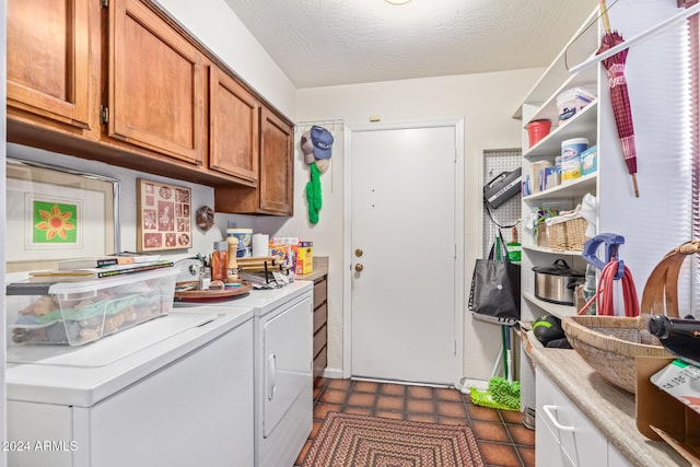 laundry room with separate washer and dryer, cabinets, and a textured ceiling