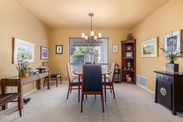 carpeted dining area featuring a chandelier and a textured ceiling