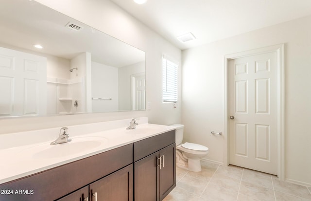 bathroom featuring tile patterned flooring, vanity, toilet, and walk in shower