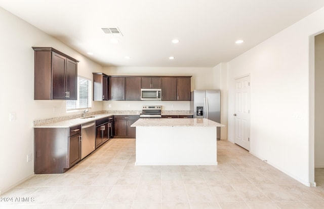 kitchen featuring a center island, sink, dark brown cabinetry, and stainless steel appliances