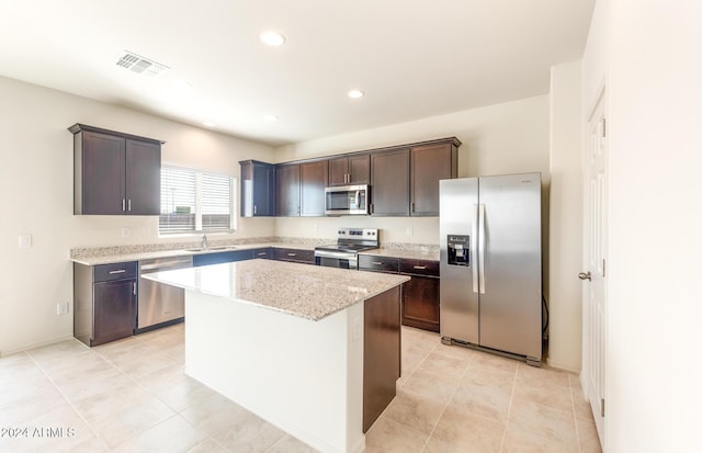 kitchen with dark brown cabinetry, sink, a center island, and appliances with stainless steel finishes