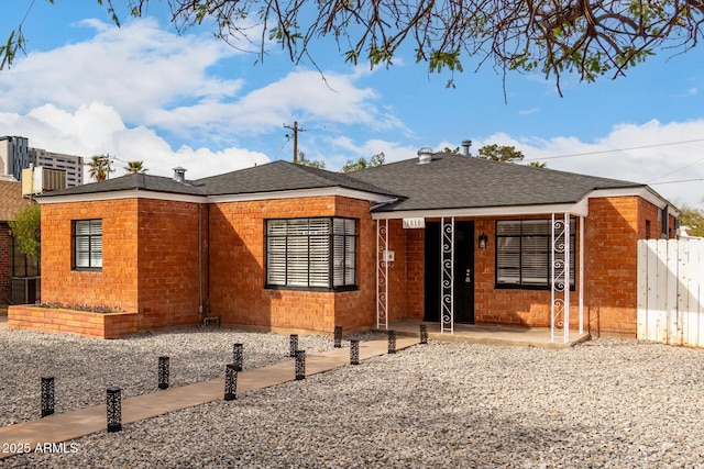 view of front of home with roof with shingles and fence