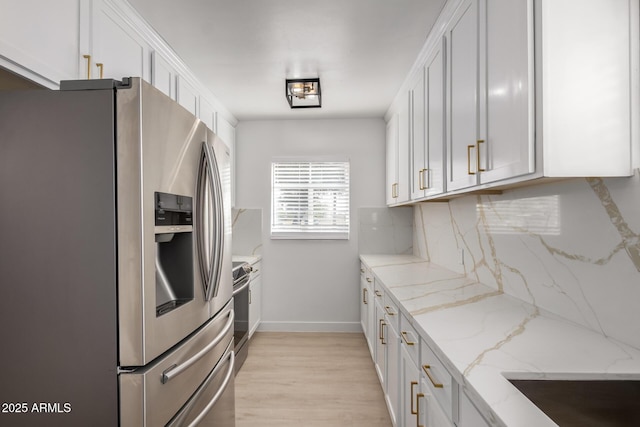 kitchen with decorative backsplash, light stone counters, white cabinetry, and appliances with stainless steel finishes