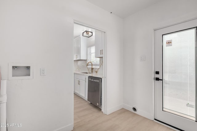 interior space with light wood finished floors, baseboards, and a sink