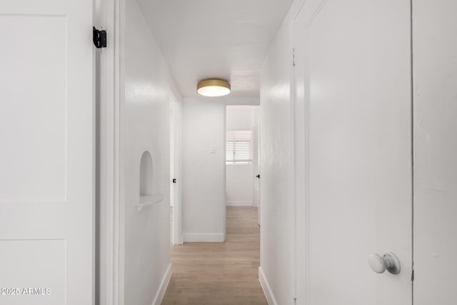 hallway with wood finished floors and baseboards