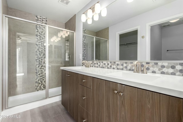 bathroom featuring walk in shower, vanity, and tasteful backsplash