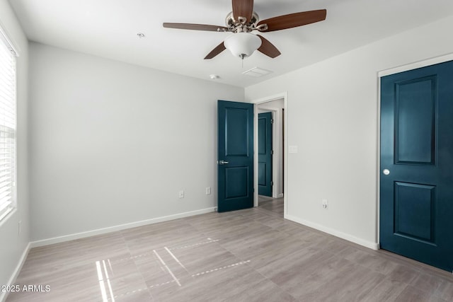 unfurnished bedroom featuring ceiling fan and multiple windows