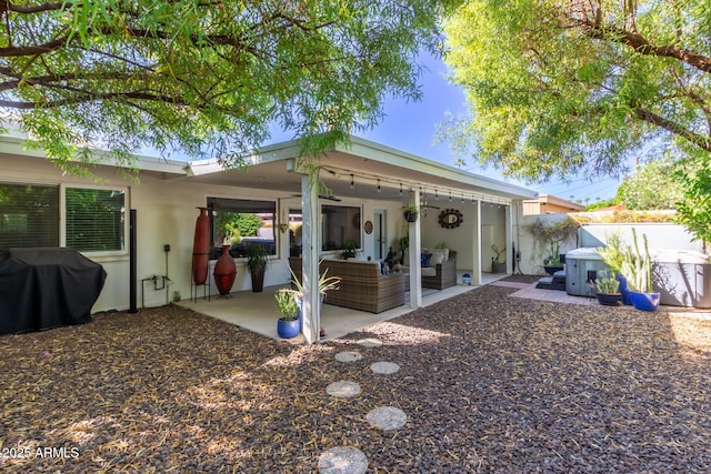 back of property with an outdoor living space and a patio