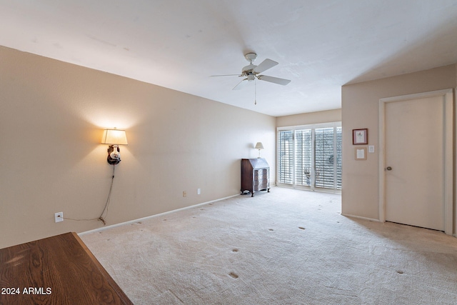 unfurnished living room featuring ceiling fan and light colored carpet