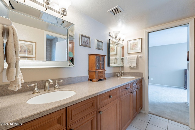 bathroom featuring tile patterned floors, vanity, and a textured ceiling