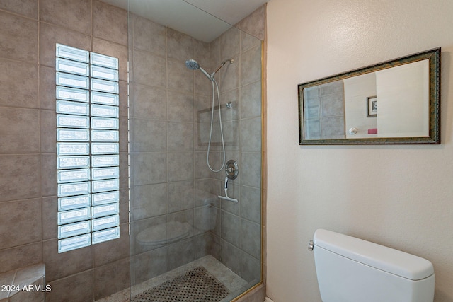 bathroom featuring toilet and a tile shower