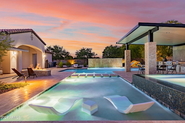 view of pool featuring a pool with connected hot tub, a patio, area for grilling, and fence