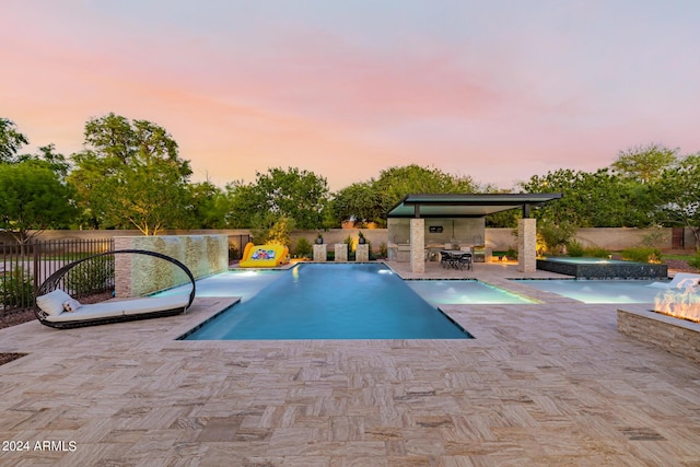 view of pool featuring a patio, an outdoor fire pit, a fenced backyard, and a pool with connected hot tub