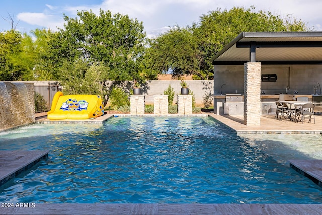 view of swimming pool with a patio, exterior kitchen, a fenced backyard, and a fenced in pool