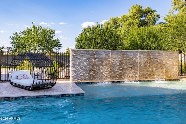 view of swimming pool featuring fence