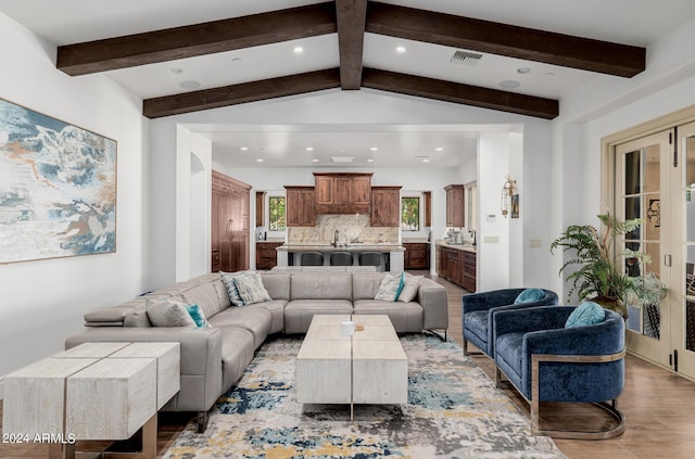 living area with vaulted ceiling with beams, light wood-style flooring, visible vents, and recessed lighting