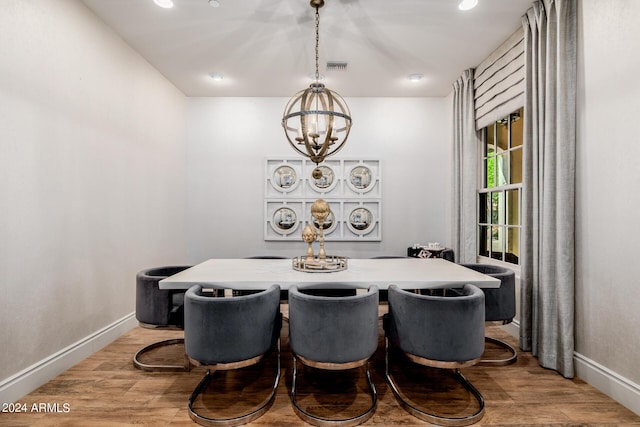 dining area featuring an inviting chandelier, baseboards, and wood finished floors