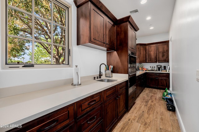 kitchen featuring visible vents, light wood-style flooring, light countertops, a sink, and recessed lighting