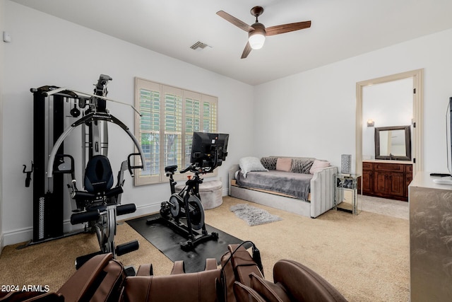 workout room with a ceiling fan, light carpet, visible vents, and baseboards