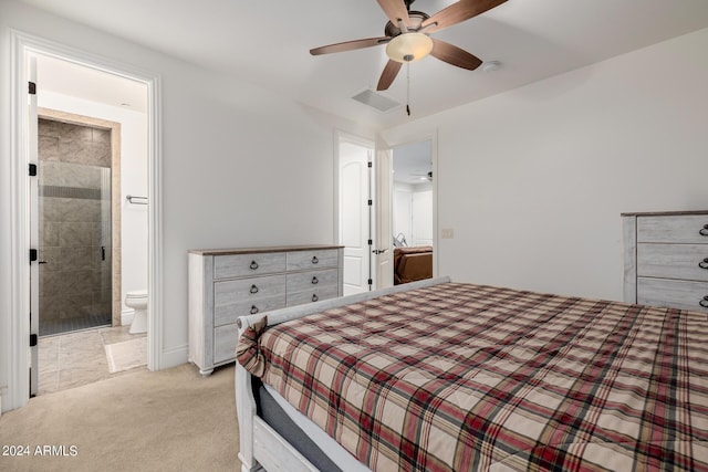 bedroom with ensuite bathroom, ceiling fan, visible vents, and light colored carpet