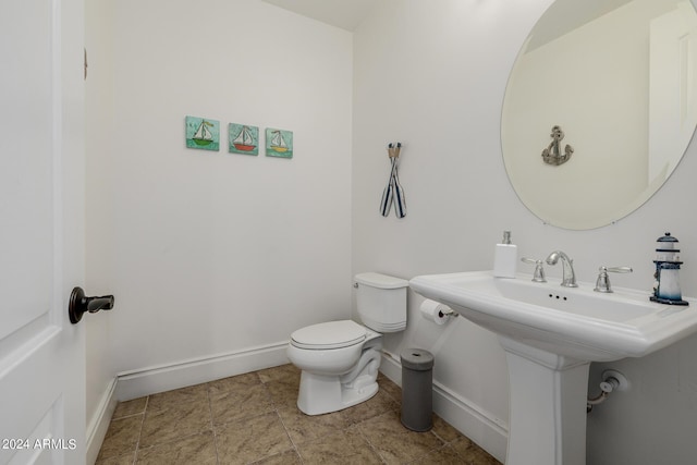 half bath featuring toilet and baseboards