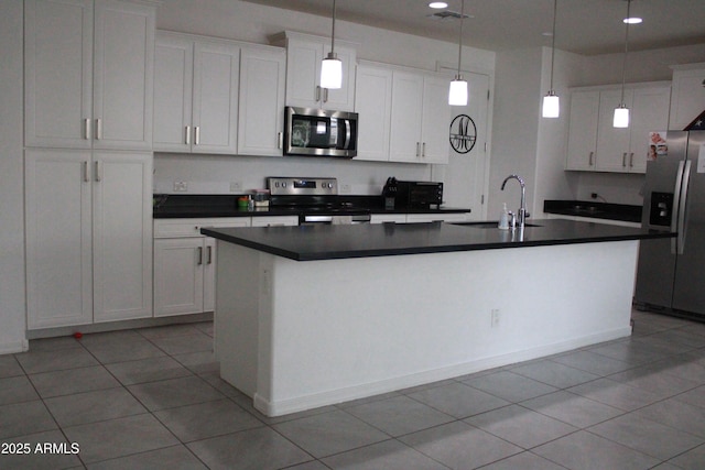 kitchen featuring appliances with stainless steel finishes, pendant lighting, an island with sink, sink, and white cabinets