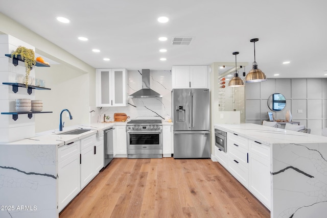 4910 E Shaw Butte Dr, Scottsdale, AZ 85254 - kitchen featuring stainless steel appliances, wall chimney range hood, a sink, a peninsula, and light stone counters