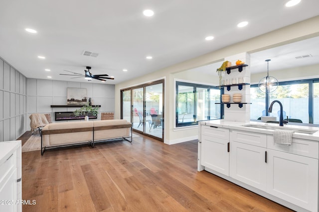 4910 E Shaw Butte Dr, Scottsdale, AZ 85254 - kitchen with a sink, white cabinetry, light wood-style flooring, ceiling fan, and recessed lighting
