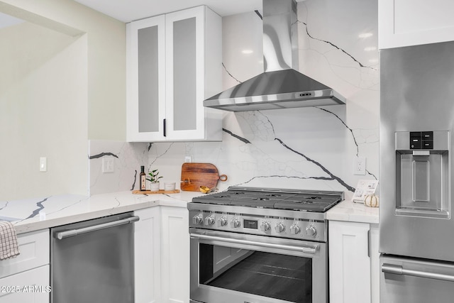 4910 E Shaw Butte Dr, Scottsdale, AZ 85254 - kitchen with wall chimney exhaust hood, appliances with stainless steel finishes, white cabinets, decorative backsplash, and glass insert cabinets