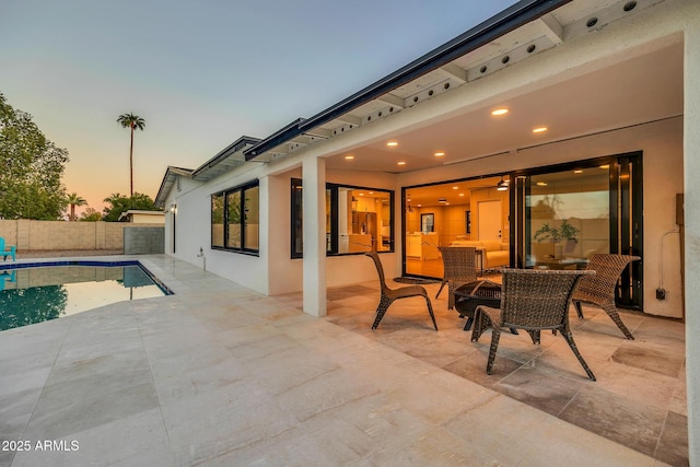 4910 E Shaw Butte Dr, Scottsdale, AZ 85254 - patio terrace at dusk with a patio area, a fenced backyard, and an outdoor fire pit