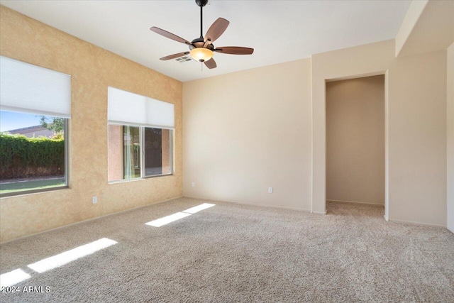 empty room featuring carpet flooring and ceiling fan