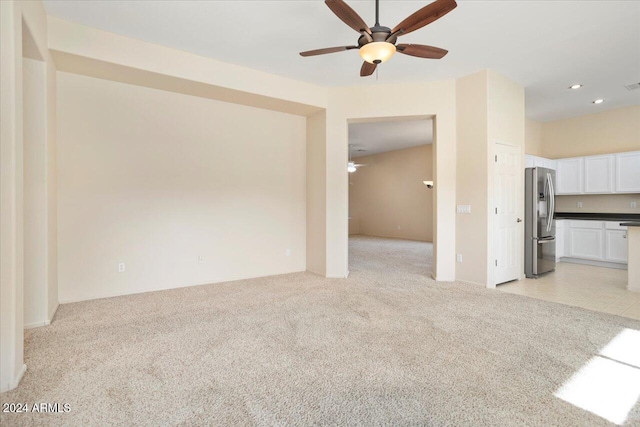 unfurnished living room with ceiling fan and light carpet