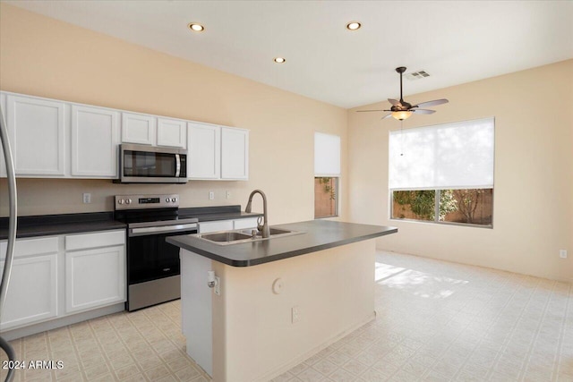 kitchen with ceiling fan, sink, a center island with sink, white cabinets, and appliances with stainless steel finishes