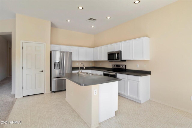 kitchen featuring an island with sink, stainless steel appliances, white cabinetry, and sink