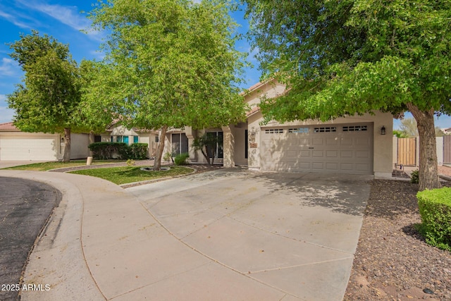 view of property hidden behind natural elements featuring a garage, fence, stucco siding, and driveway