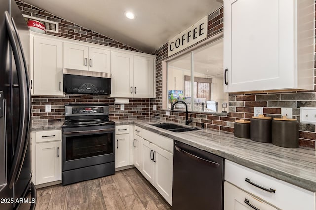 kitchen featuring range with electric stovetop, black fridge with ice dispenser, vaulted ceiling, a sink, and dishwashing machine