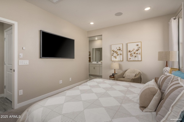 bedroom with ensuite bathroom and light colored carpet