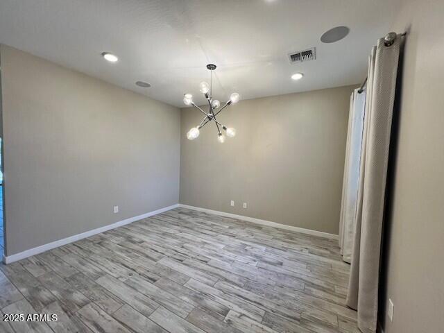17066 W Seldon Ln, Waddell, AZ 85355 - spare room featuring wood finished floors, a chandelier, baseboards, and recessed lighting