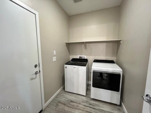 17066 W Seldon Ln, Waddell, AZ 85355 - laundry area featuring washing machine and clothes dryer, light wood finished floors, and baseboards