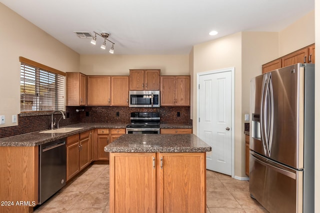 kitchen featuring light tile patterned flooring, backsplash, sink, a kitchen island, and stainless steel appliances