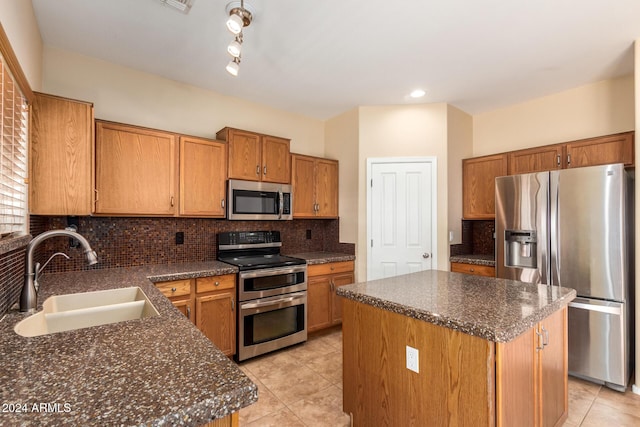 kitchen featuring decorative backsplash, sink, a center island, and appliances with stainless steel finishes